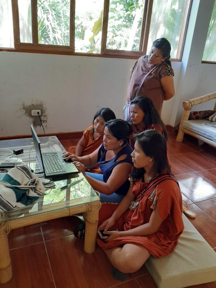 Indigenous people of the Peruvian Amazonia using a laptop
